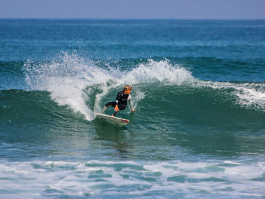 Confident surfer riding a wave during coached surf session with WildMex in Punta Mita, Mexico