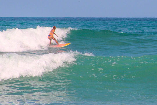 Surfer riding a fast wave at La Lancha beach, accessible from San Pancho