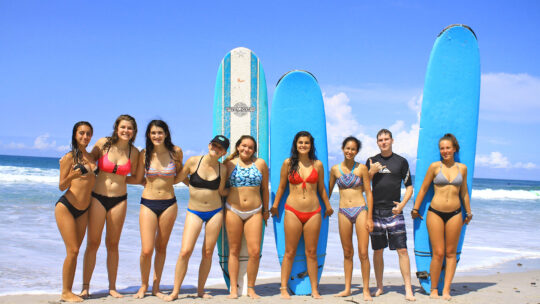 Group of young surfers posing with boards after a WildMex Surf Camp lesson in Sayulita, Mexico